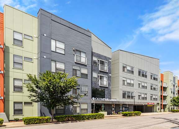 A modern apartment building with the name "OLYMPICS" on the front.
