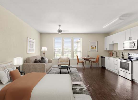 A well-lit, modern kitchen and living room with a large bed in the foreground.
