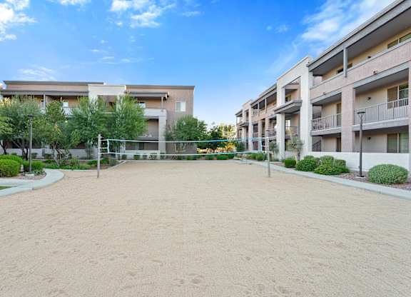 A sandy area in front of apartment buildings.