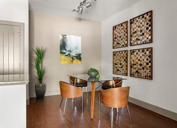 A dining room with a glass table and chairs.
