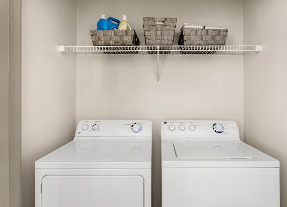 Two white front loading washing machines in a laundry room.