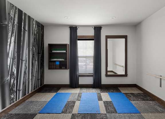 A room with a checkered carpet and a window with curtains.