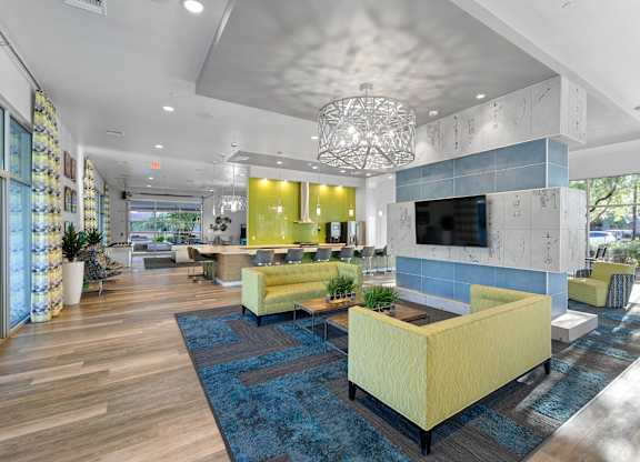 A modern living room with a yellow sofa and a blue rug.