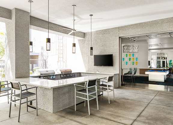 A modern kitchen with a large island and chairs.