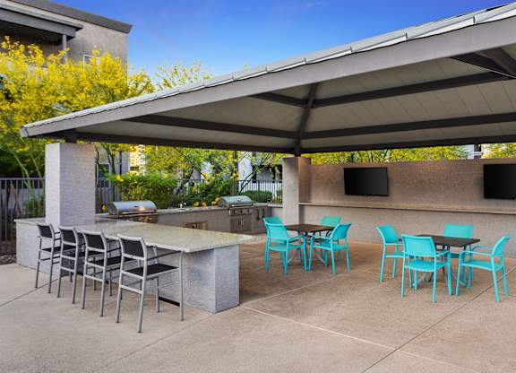 A patio with a table and chairs under a roof.