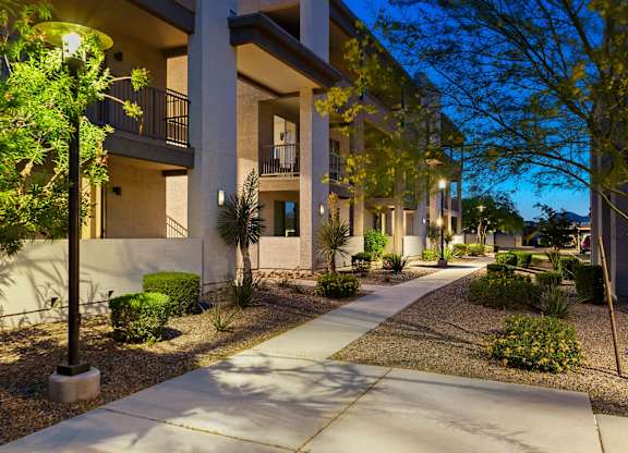 A sunny day in a residential area with apartment buildings and a sidewalk.