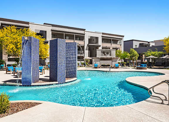 A swimming pool surrounded by a concrete patio and a metal railing.