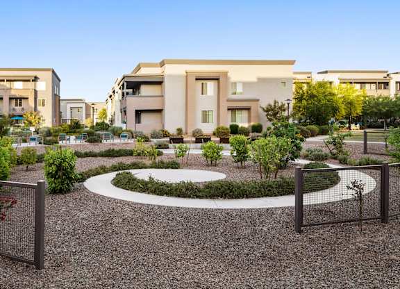 A modern building with a circular garden in front.