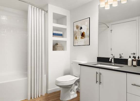 A white bathroom with a toilet, sink, and shower curtain.