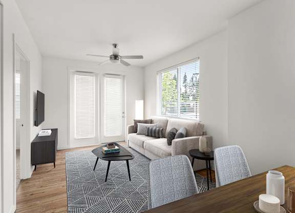 A living room with a couch, chairs, and a television.