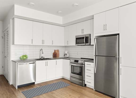 A modern kitchen with stainless steel appliances and white cabinets.