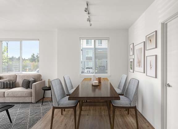 A dining room with a wooden table and grey chairs.