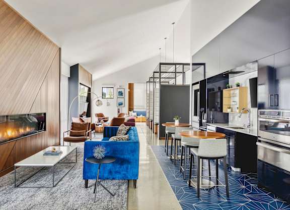 A modern living room with a fireplace and a blue couch.