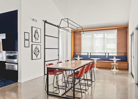 A modern dining room with a long table and chairs.