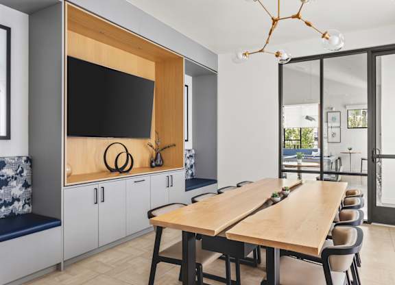 A modern dining room with a wooden table and chairs.