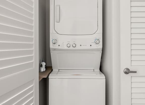 A white toilet is installed in a small white room.