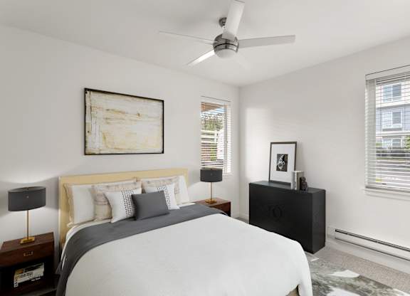 A bedroom with a bed, nightstand, and a painting on the wall.