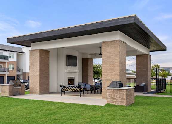 A covered patio area with a table and chairs.