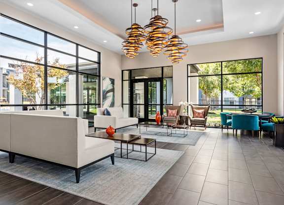 A modern living room with a large white sofa and a glass door.