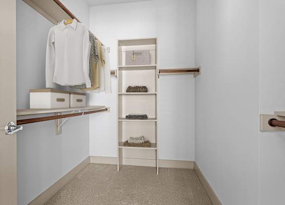 A white closet with a shelf and a white door.