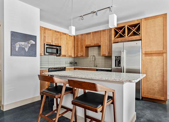 A kitchen with wooden cabinets and a marble countertop.