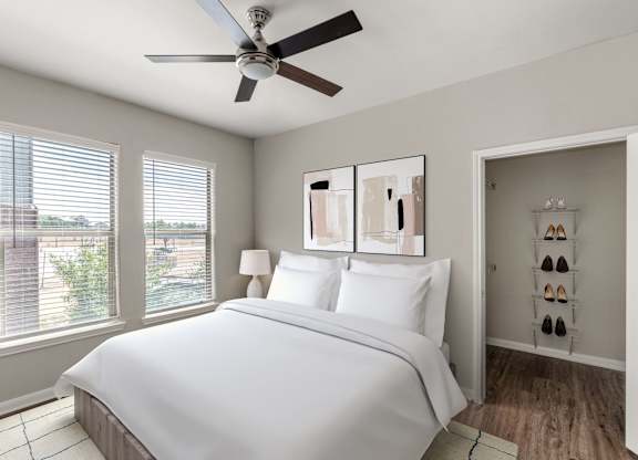 A bedroom with a large bed and a ceiling fan.