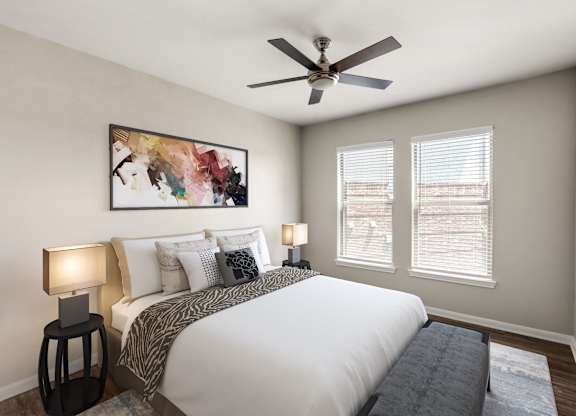 A bedroom with a large bed, two lamps, and a painting on the wall.