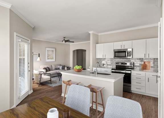 A kitchen with a white countertop and a white ceiling fan.