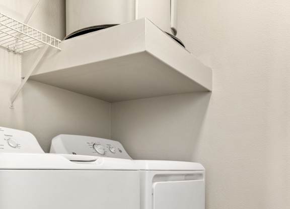A white dryer and washer in a small laundry room.