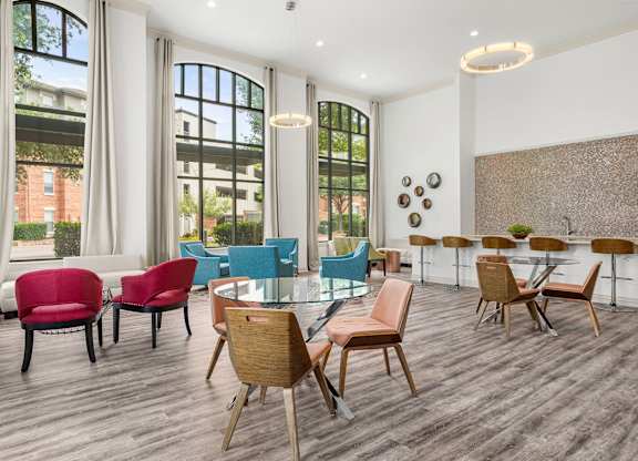 A room with a long table and chairs in front of a window.