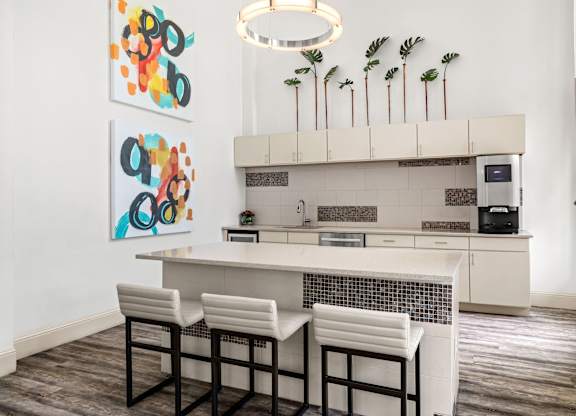 A kitchen with a white counter and bar stools.