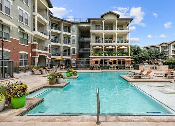 A large swimming pool in front of apartment buildings.