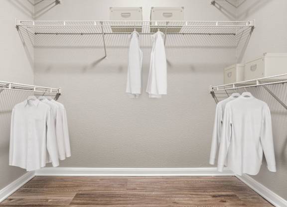 A white shirt is hanging on a clothes rack in a room.