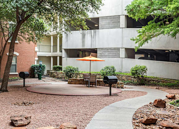 A courtyard with a table and chairs and a mailbox.