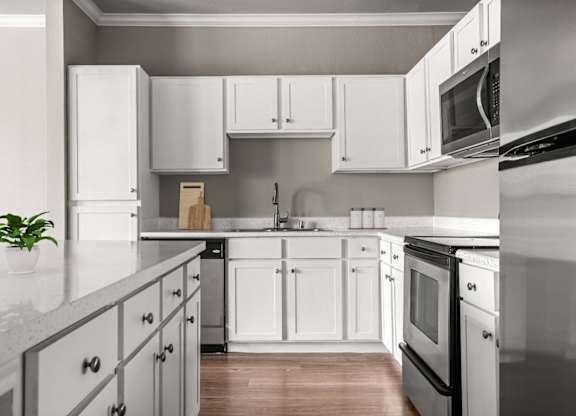 A kitchen with white cabinets and appliances.