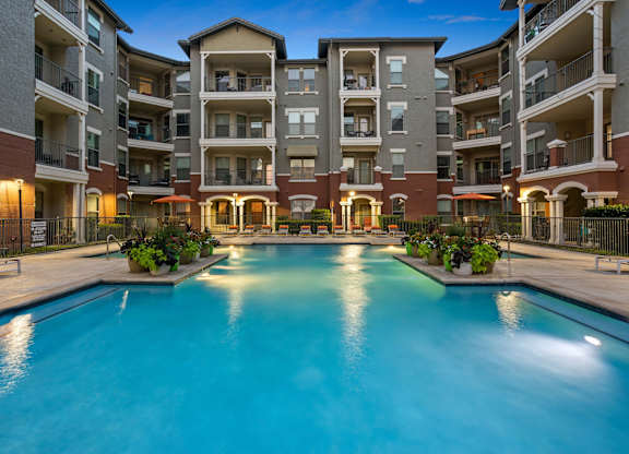 A large swimming pool in front of apartment buildings.