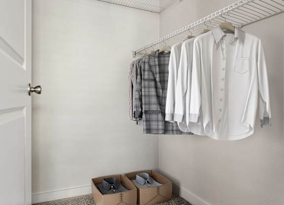 A white shirt is hanging on a clothes rack next to a pair of shoes in a white closet.
