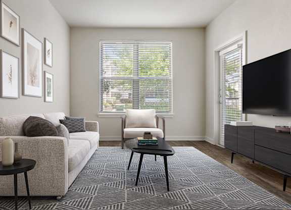 A living room with a couch, chair, and a television.