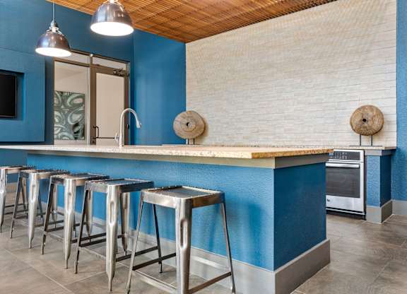 A kitchen with blue walls and a wooden ceiling.
