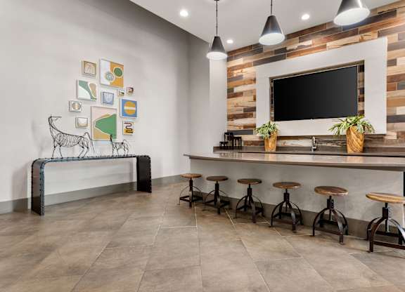 A modern bar area with a wooden wall and a bench with a cow print.