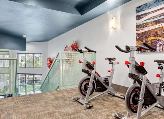 A room with a treadmill and a stationary bike.