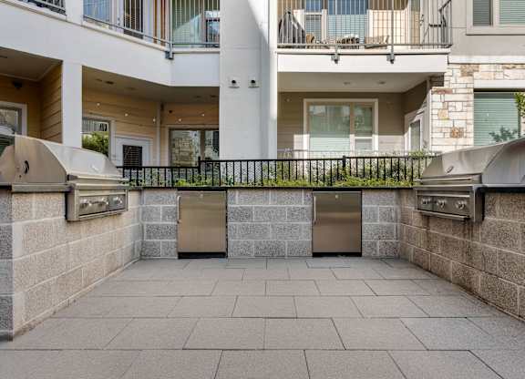 A courtyard with a black fence and a stone wall.