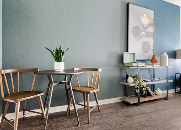 A dining table with chairs and a plant on it.