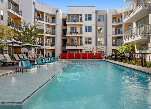 A swimming pool in front of apartment buildings.