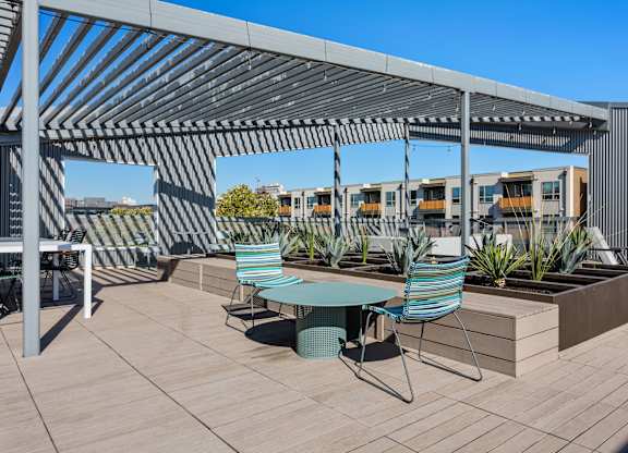 A patio with a table and chairs under a pergola.