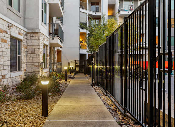 A black metal fence runs along the side of a sidewalk.