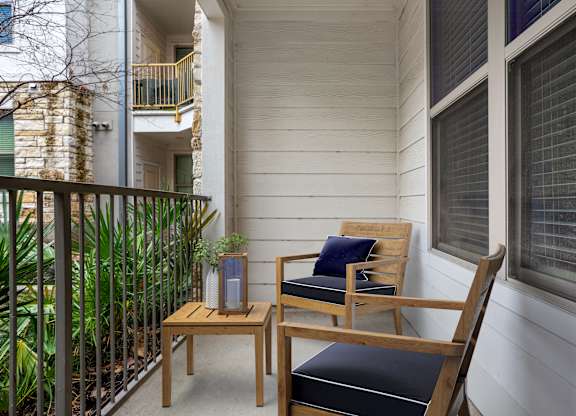 A wooden chair with a cushion sits on a patio.