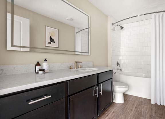 A bathroom with a white sink and a white toilet.