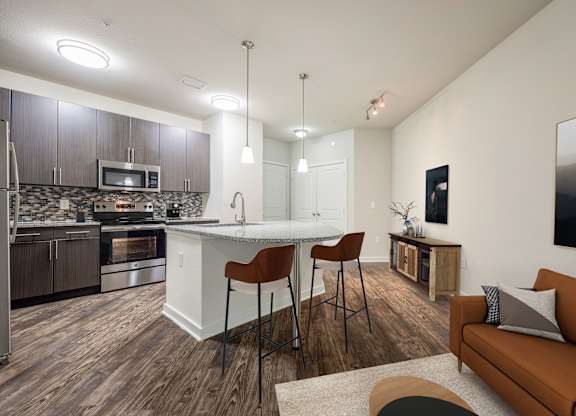A modern kitchen with a bar and a couch.