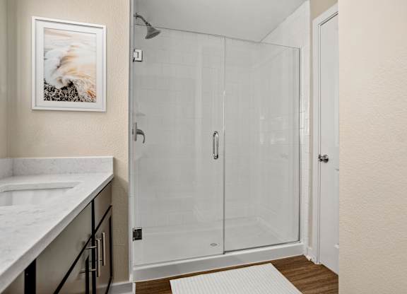 A white bathroom with a walk in shower.